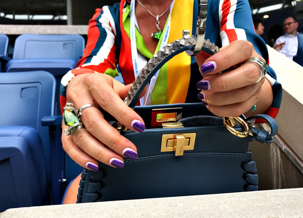 NEW YORK, NY - SEPTEMBER 09:  A tennis fan places her designer bag on a hanger in box seats at Arthur Ashe stadium during Day Twelve of the 2016 US Open at the USTA Billie Jean King National Tennis Center on September 9, 2016 in Queens.  (Landon Nordeman for ESPN)